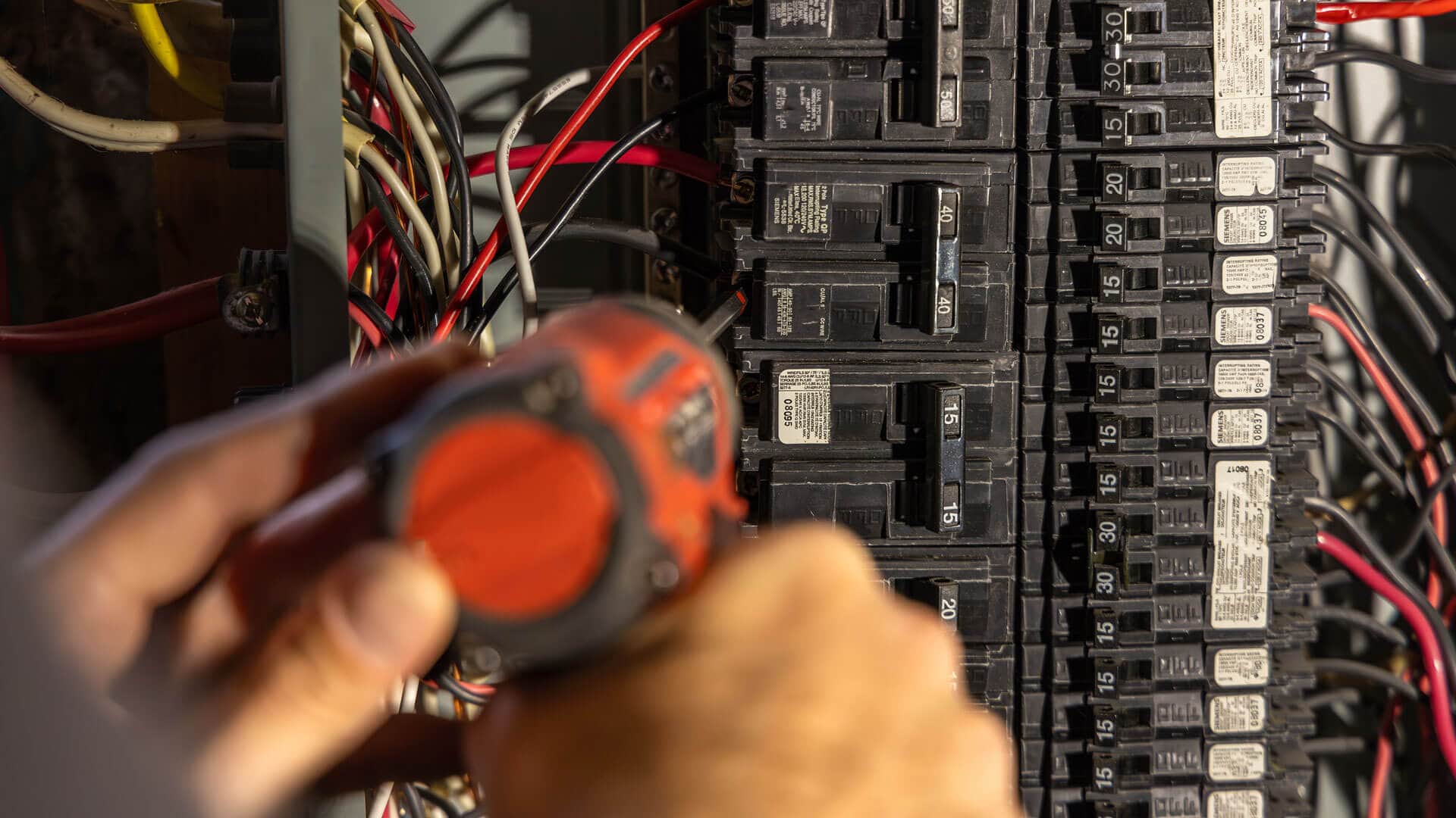 electrician-is-installing-an-electrical-circuit-breaker-in-a-power-panel-using-a-screwdriver
